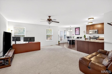 Living area featuring a chandelier, healthy amount of natural light, a ceiling fan, and an office area