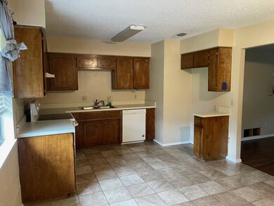 Kitchen featuring sink, a textured ceiling, white 