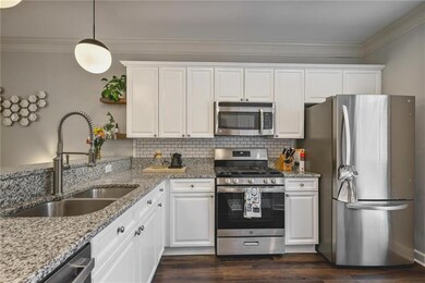 Kitchen with appliances with stainless steel finishes, open shelves, white cabinets, and ornamental molding