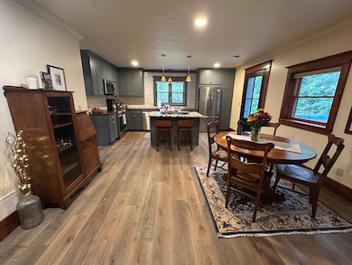 The open concept design with the eco-friendly waterproof flooring blends the Great Room, into the Dining area, into the Kitchen.