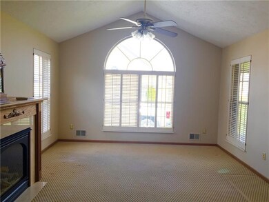 The open floor plan features a huge Palladian window, gas fireplace and shutters.