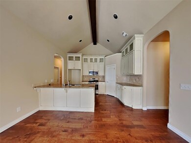 Kitchen with vaulted ceiling with beams, white cab