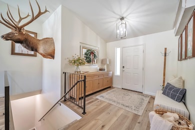 Entryway featuring light wood-style floors and a chandelier