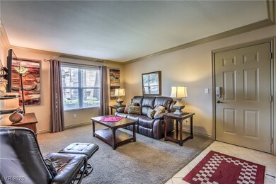 Living room featuring crown molding, light tile pa