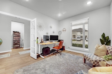 Office space featuring french doors, light wood-style floors, and recessed lighting