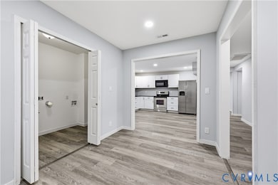 Corridor with light wood-style flooring and recessed lighting