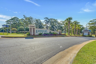 View of asphalt road featuring street lighting, curbs, and sidewalks