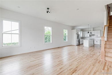 Unfurnished living room with light wood-style floo