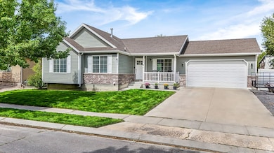 Ranch-style home with a porch, a front lawn, driveway, an attached garage, and roof with shingles