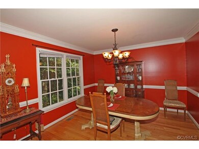 The dining room with arched opening has hardwood f