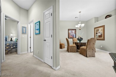 Corridor with light carpet and an inviting chandel