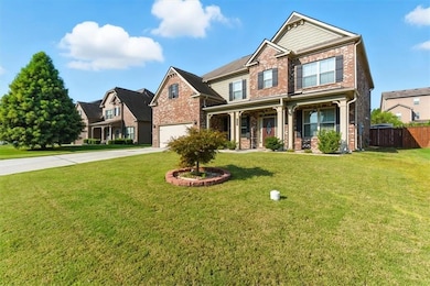 Craftsman-style home featuring brick siding, driveway, and a porch