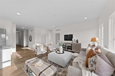 Living area with recessed lighting and light wood-style flooring