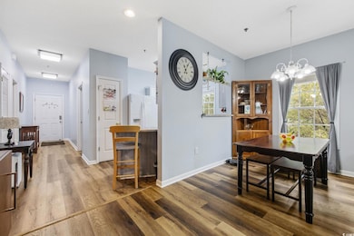 Dining area with wood finished floors, a chandelie