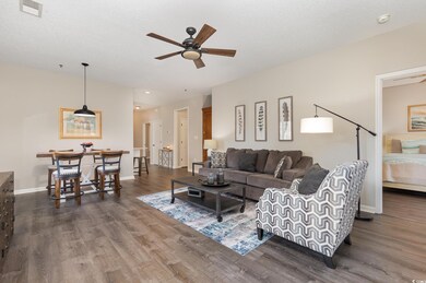 Living room featuring visible vents, baseboards, dark wood finished floors, and a ceiling fan
