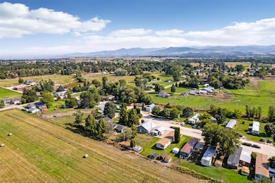 Aerial view of sparsely populated area featuring a mountainous background and nearby suburban area