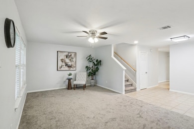 Sitting room with carpet, ceiling fan, stairway, 