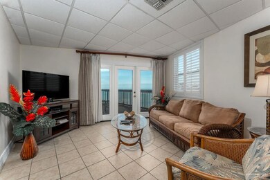 Living area featuring light tile patterned floors, visible vents, and a drop ceiling