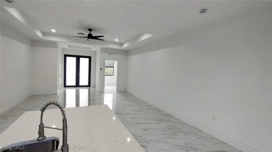 Corridor featuring french doors, a tray ceiling, a
