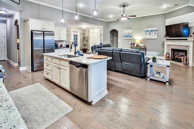 Kitchen featuring arched walkways, a sink, open fl