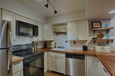 Kitchen with wooden counters, open shelves, black