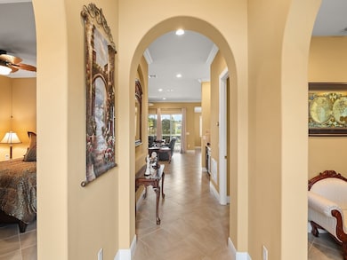 Hall featuring arched walkways, light tile patterned floors, recessed lighting, and ornamental molding