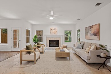Living room with a ceiling fan, light tile patter