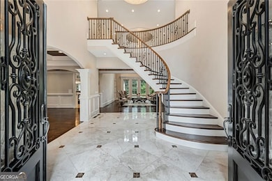 Stunning foyer with marble floors, circular stairway, dome ceiling and crystal chandelier.