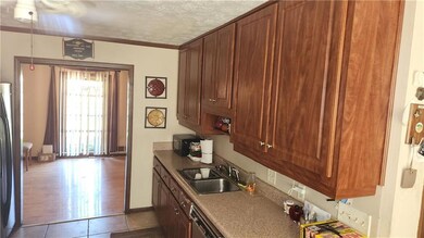 Kitchen with a sink, a textured ceiling, tile patt