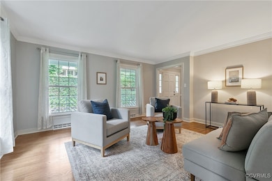 Living area with crown molding and light wood fini