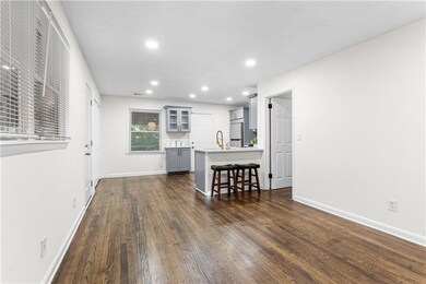 Living area featuring dark wood-type flooring and recessed lighting