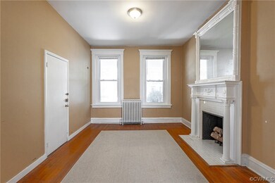 Hardwood floored living room with radiator and a f