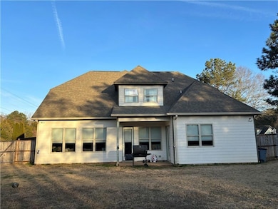 Rear view of property with a shingled roof