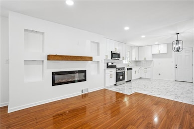 Kitchen with visible vents, white cabinets, basebo