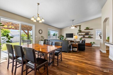 Dining area with lofted ceiling, dark wood finished floors, a ceiling fan, a chandelier, and arched walkways