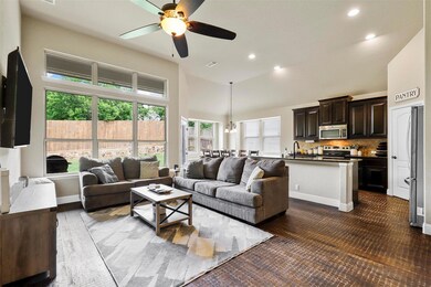Living room featuring a towering ceiling, ceiling fan, and sink