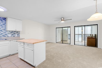 Kitchen featuring wood counters, open floor plan, tasteful backsplash, a ceiling fan, and dishwasher