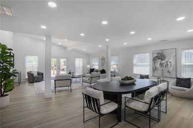 Dining space featuring a wealth of natural light, visible vents, vaulted ceiling, and light wood finished floors