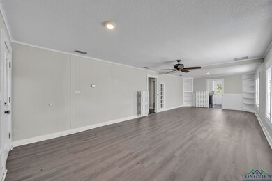 Unfurnished living room with a textured ceiling, ceiling fan, built in features, wood finished floors, and baseboards