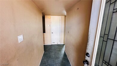 Hall with a textured wall and dark tile patterned