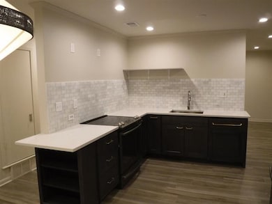 Kitchen featuring black electric range, a sink, da
