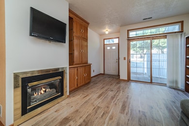 The living room has a bright patio door, custom built-in cabinets and a gas fireplace.