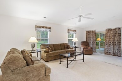 Living room featuring light colored carpet, vaulte