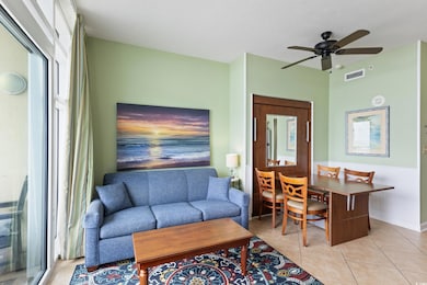 Living area with light tile patterned flooring, a ceiling fan, and a textured ceiling
