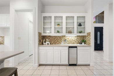 Bar with light tile patterned flooring and backsp