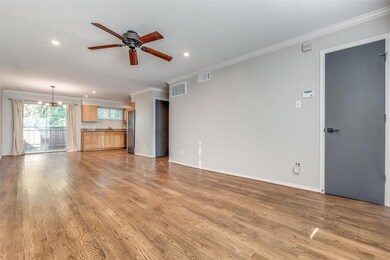 Unfurnished living room with crown molding, hardwo