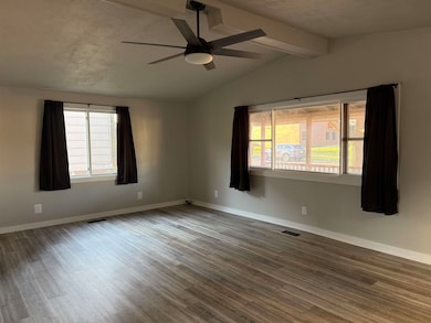 Spare room with wood finished floors and a ceiling fan