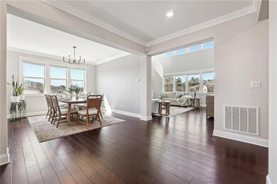Dining area with a chandelier, dark wood finished floors, ornamental molding, and recessed lighting