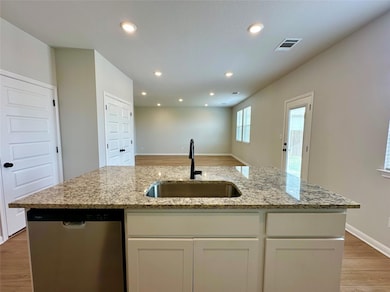 Kitchen featuring dishwasher, light wood-type flo