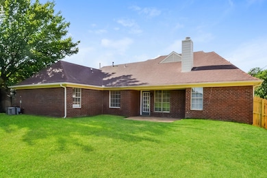 Rear view of house with a chimney, brick siding, a patio, and roof with shingles